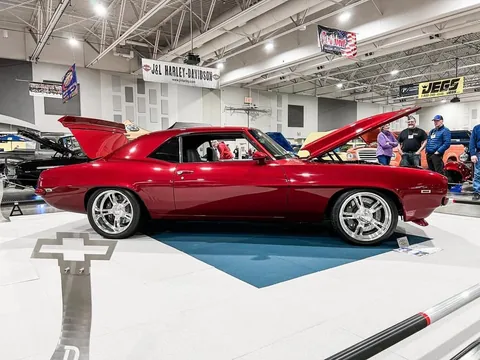 Side profile of the red 1969 Camaro on a show display